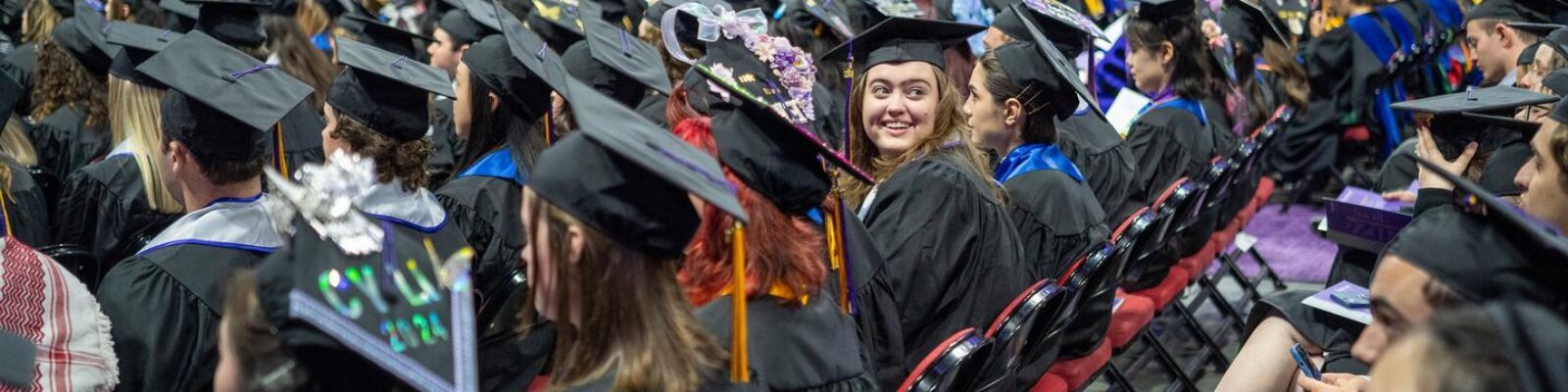 Students in regalia sittings in rows at the graduation ceremony