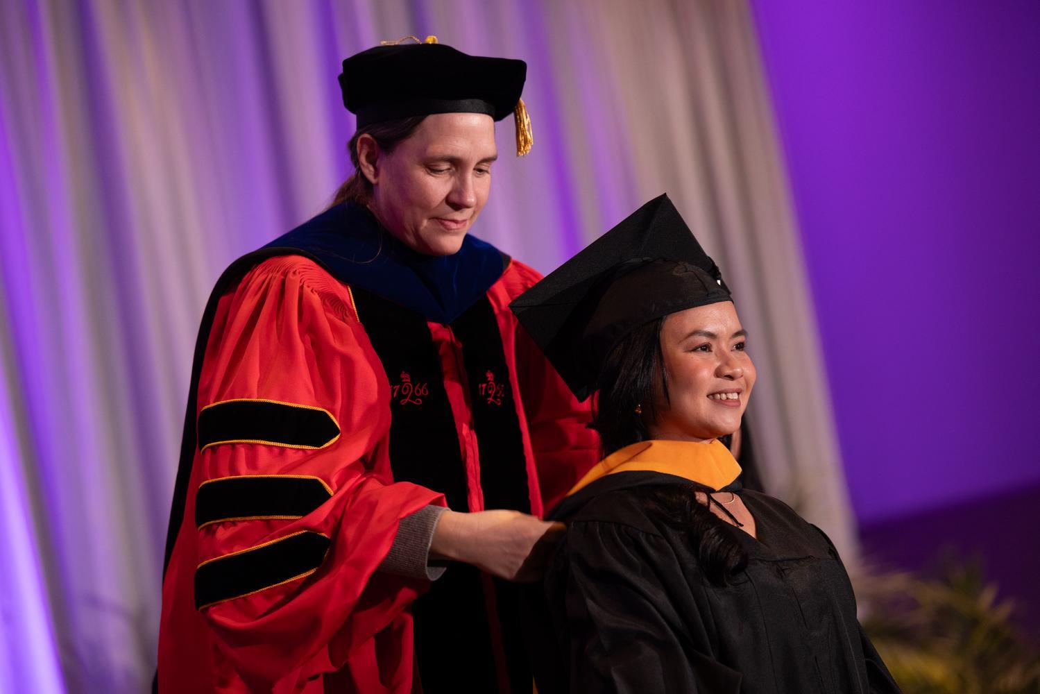 A student receiving their graduate hood